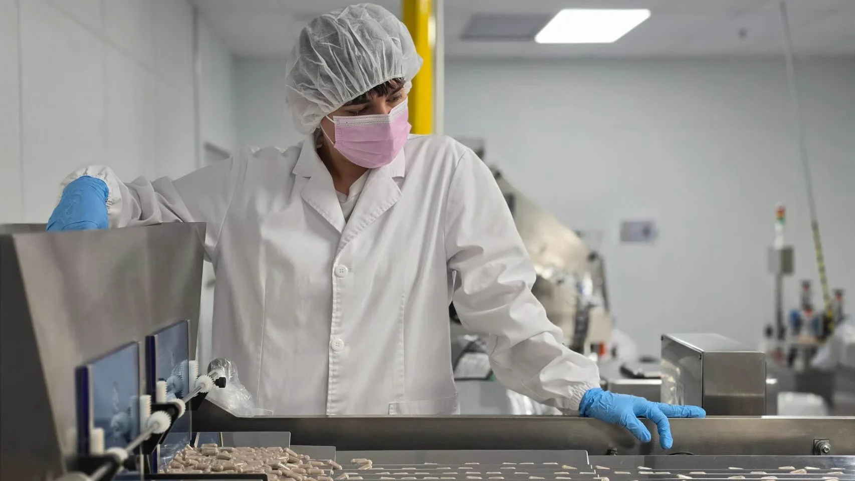 A well-dressed worker and a clean hard capsule production line